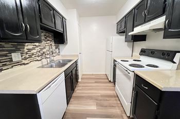 an empty kitchen with white appliances and black and white cabinets at Hunter Ridge Apartments, Cincinnati, OH